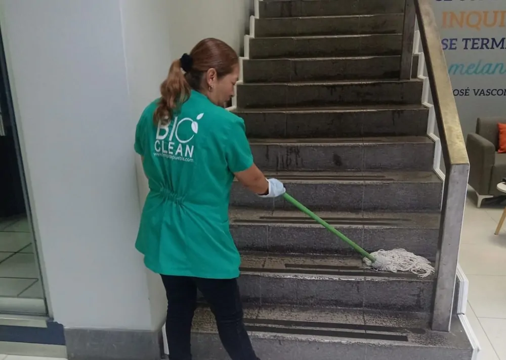 Personal de limpieza en sitio de BioClean trapeando las escaleras de un edificio
